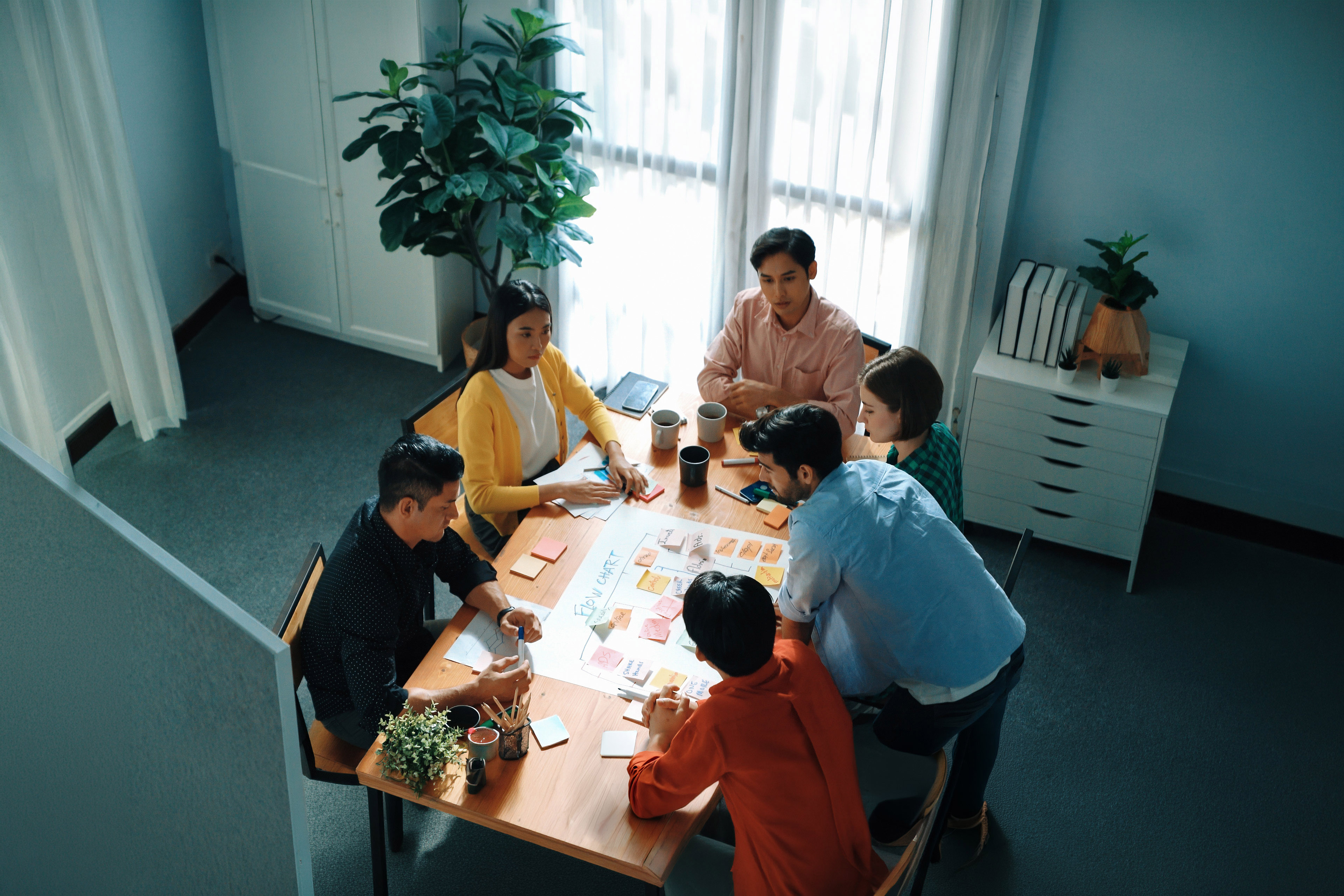 Top down view of diverse people brainstorming and making scrum task board. 
