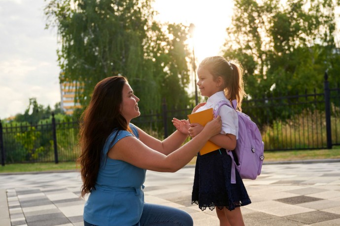 Little girl with mother on first day of school