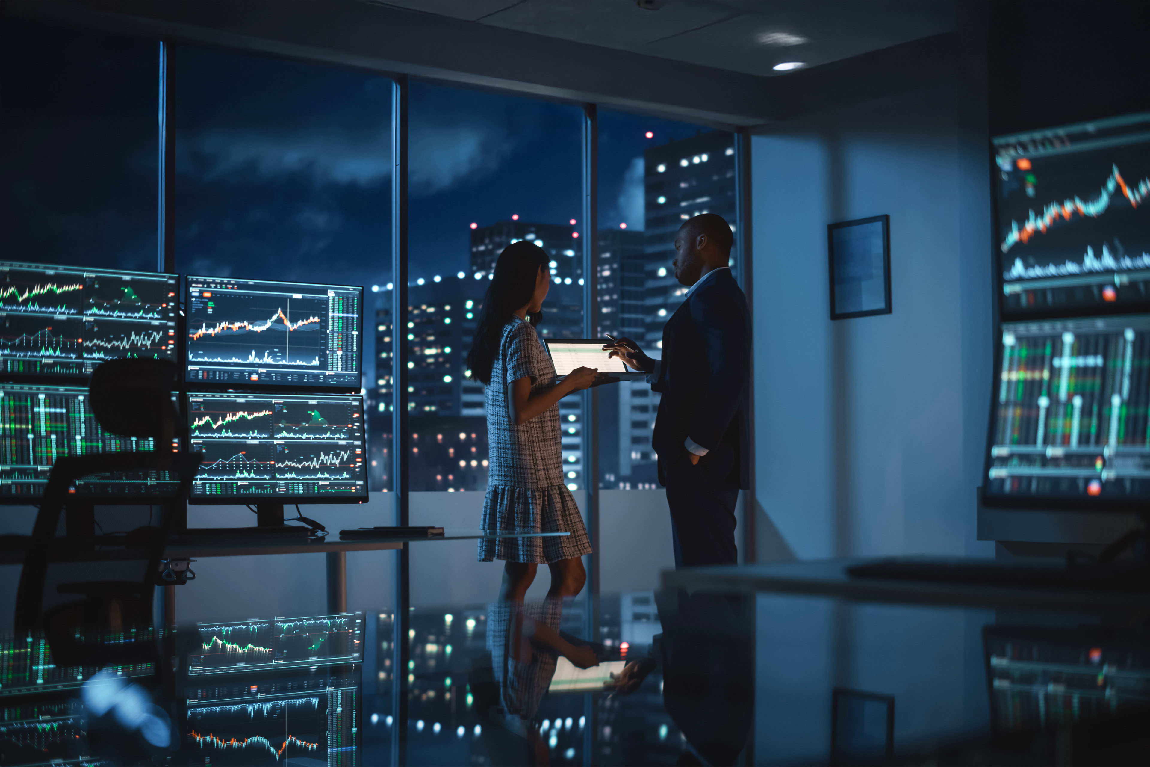 Business people sharing data on a tablet during an evening meeting