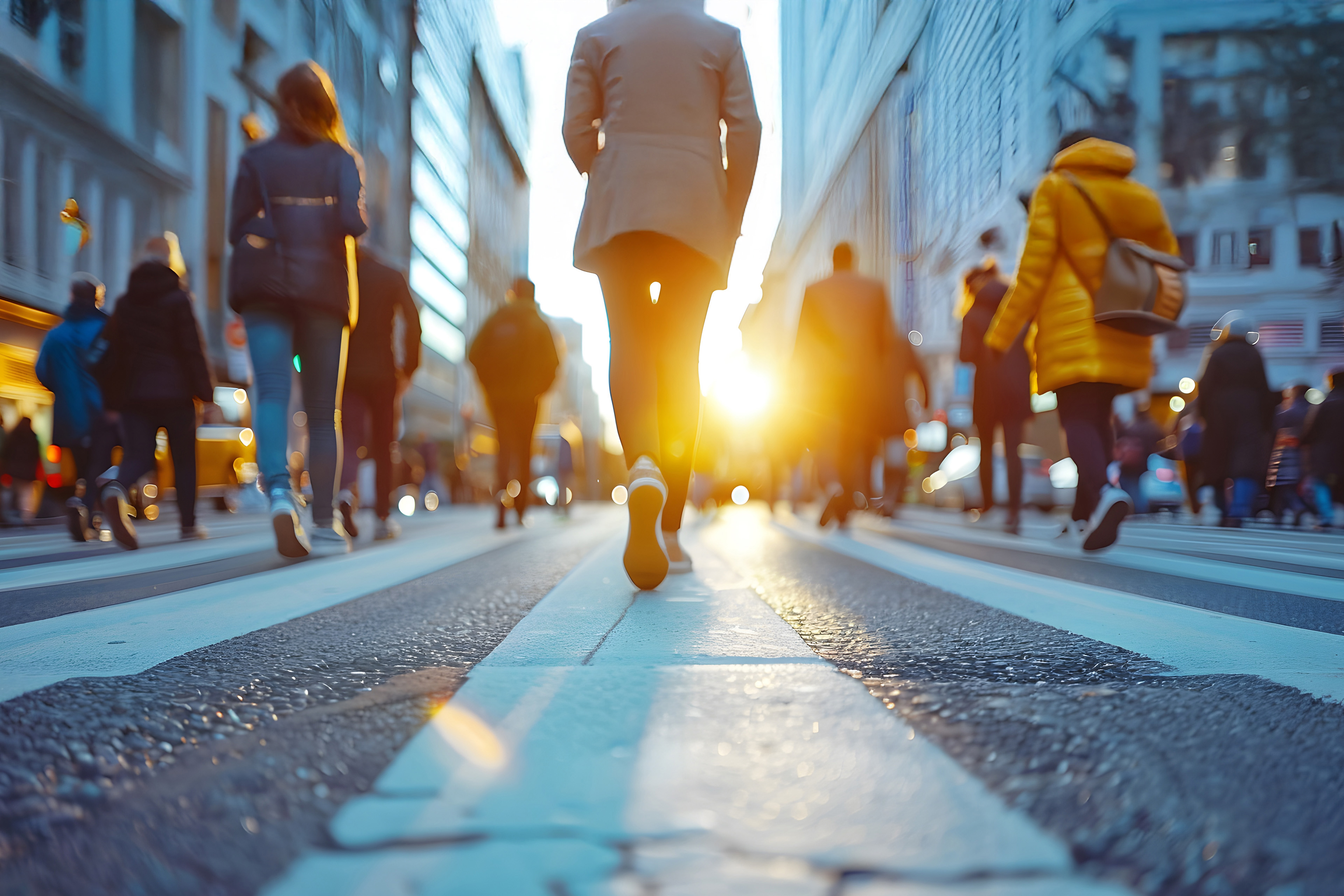 Two male workers working hardhats, carrying boxes to truck in yellow and pink sun set