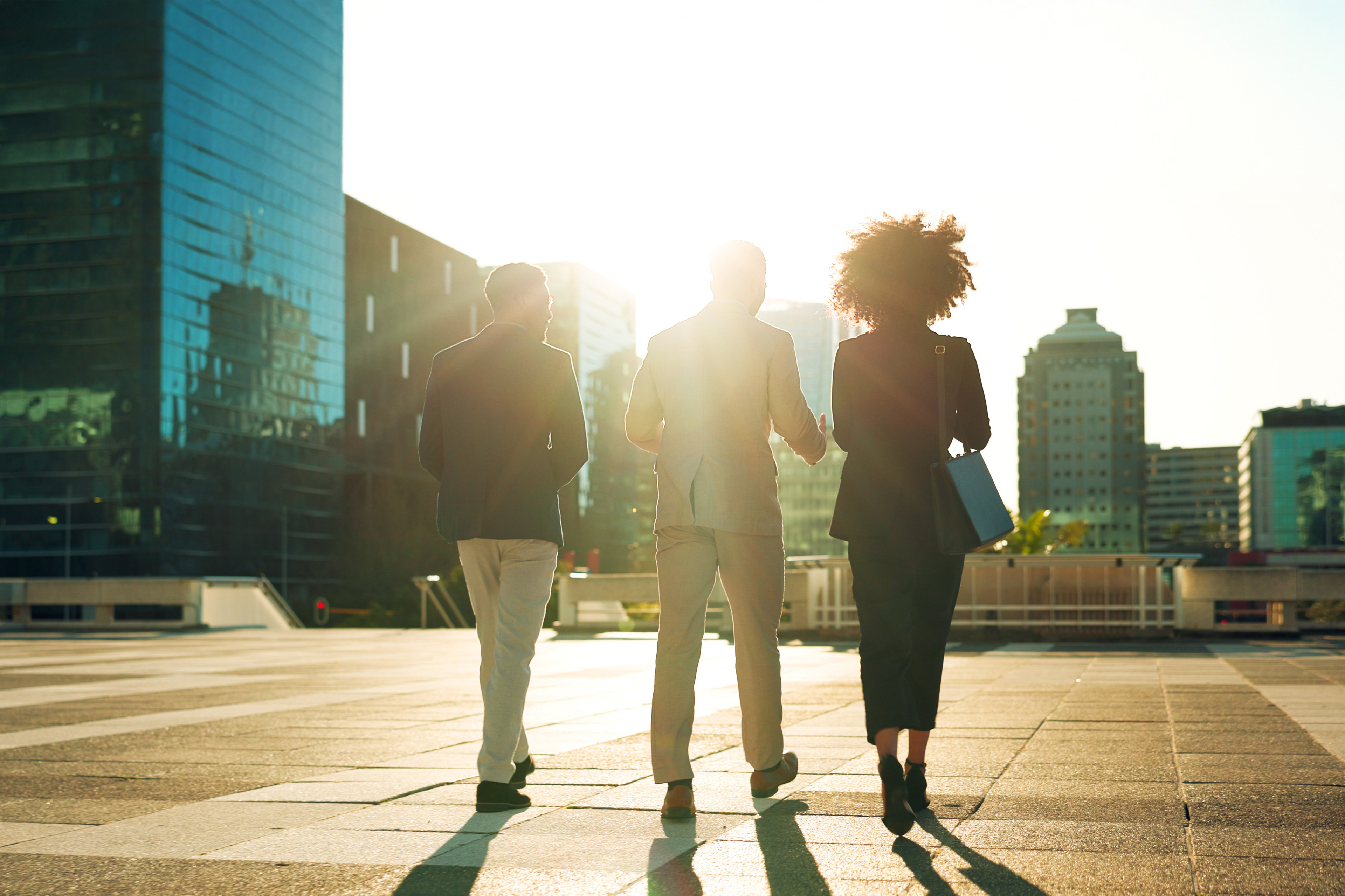 Business team and walking outdoor in city for morning travel to work, conversation and lens flare