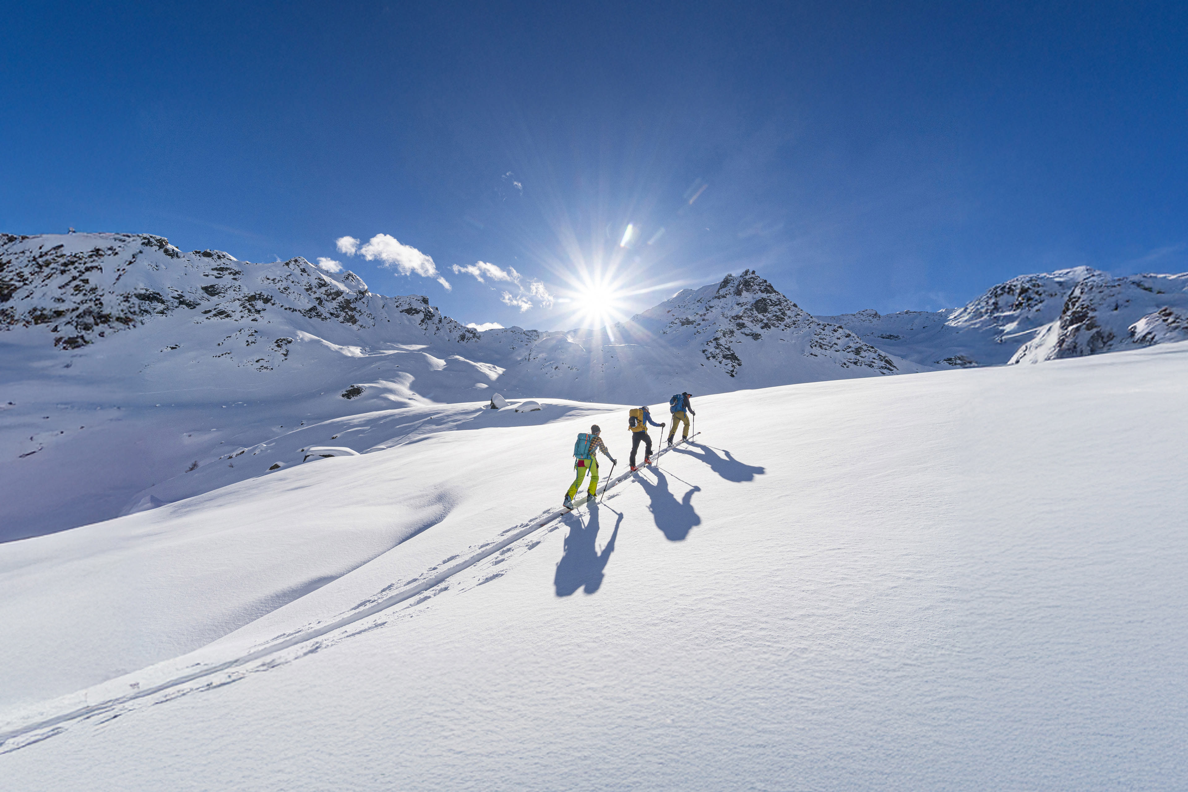 Ski mountaineers in a row walking on snowy mountain