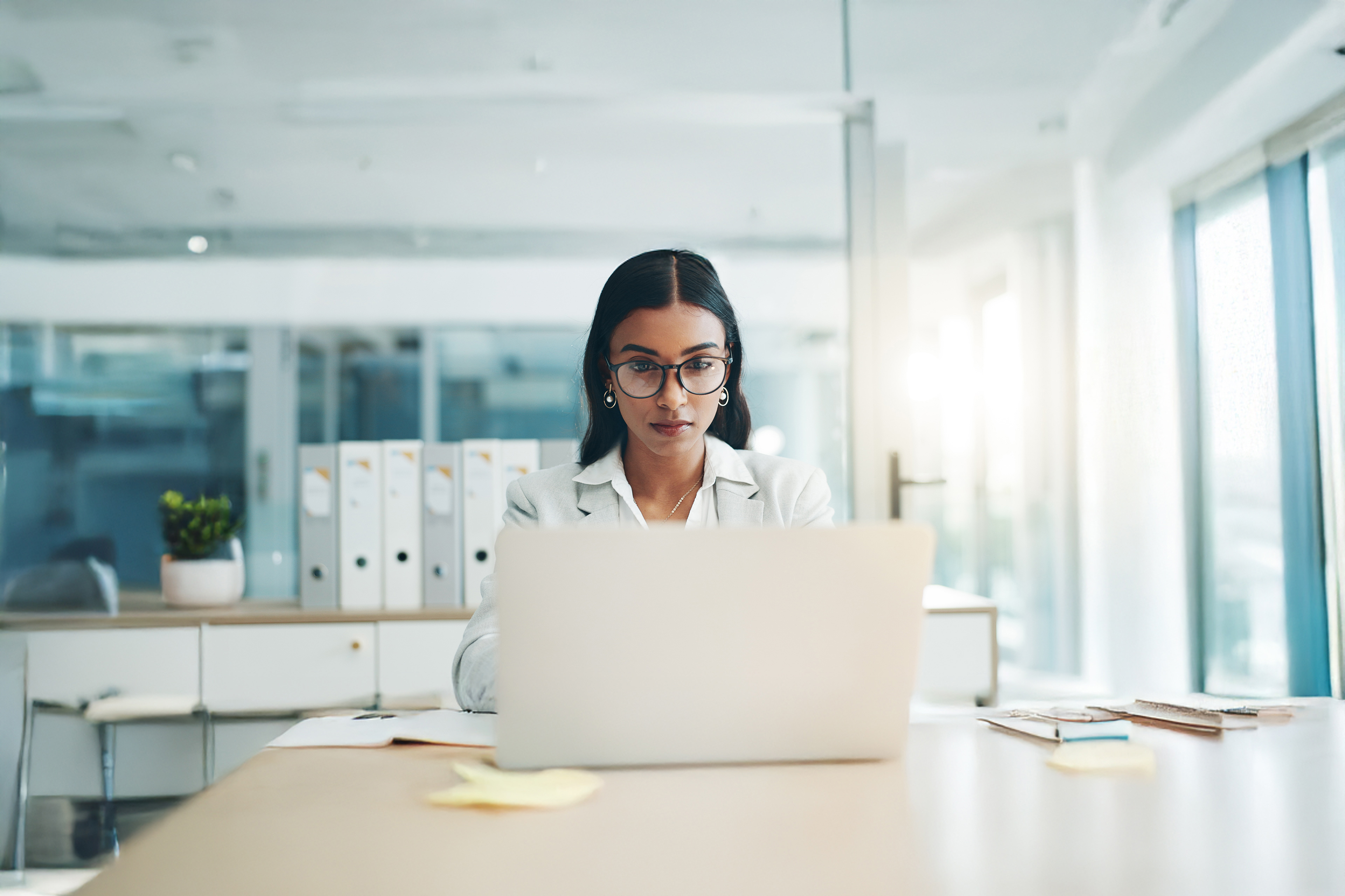 Business woman, glasses and working on laptop in office for planning, reading email and internet research in law firm.
