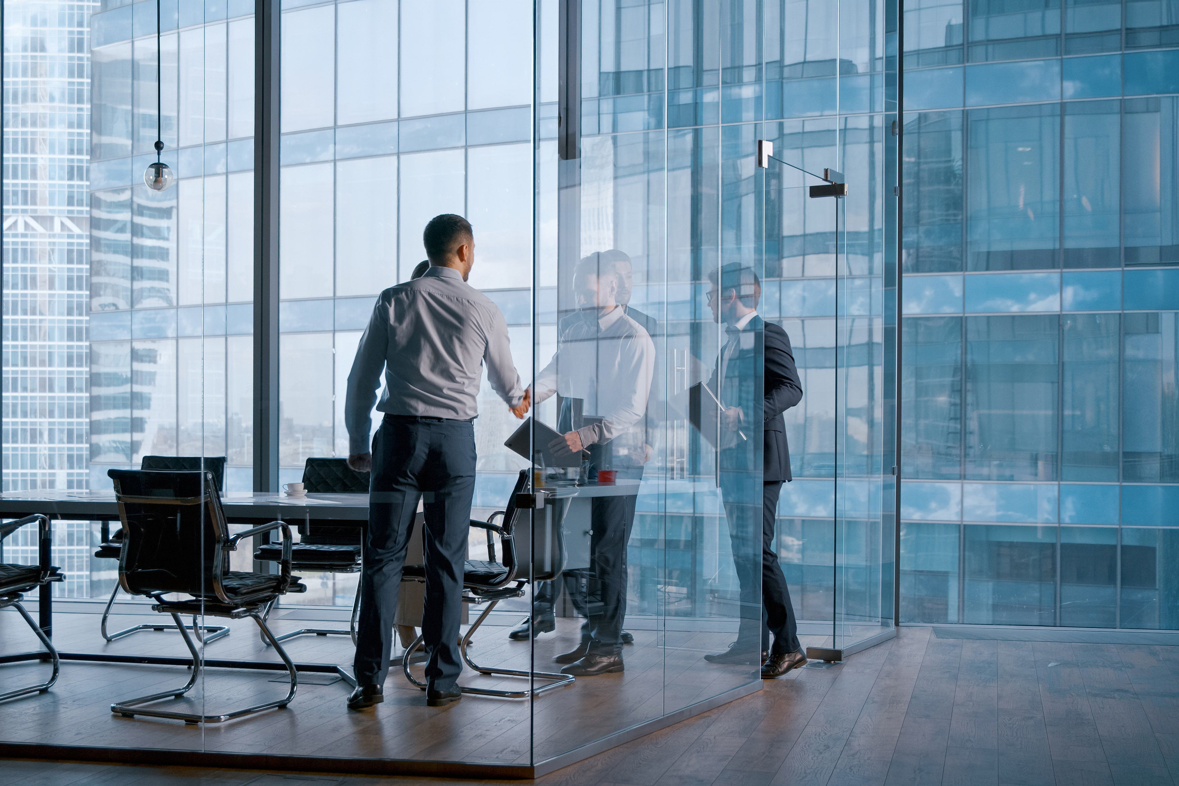 Team members collaborating in a bright, glass-enclosed meeting room