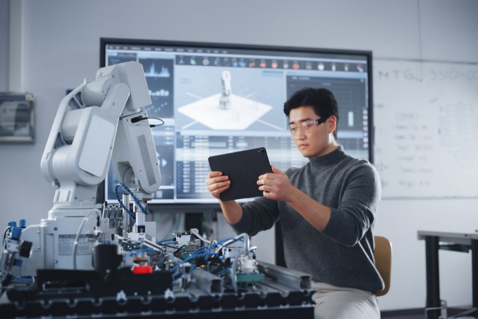 Student Holding Tablet and Controlling Robot Hand