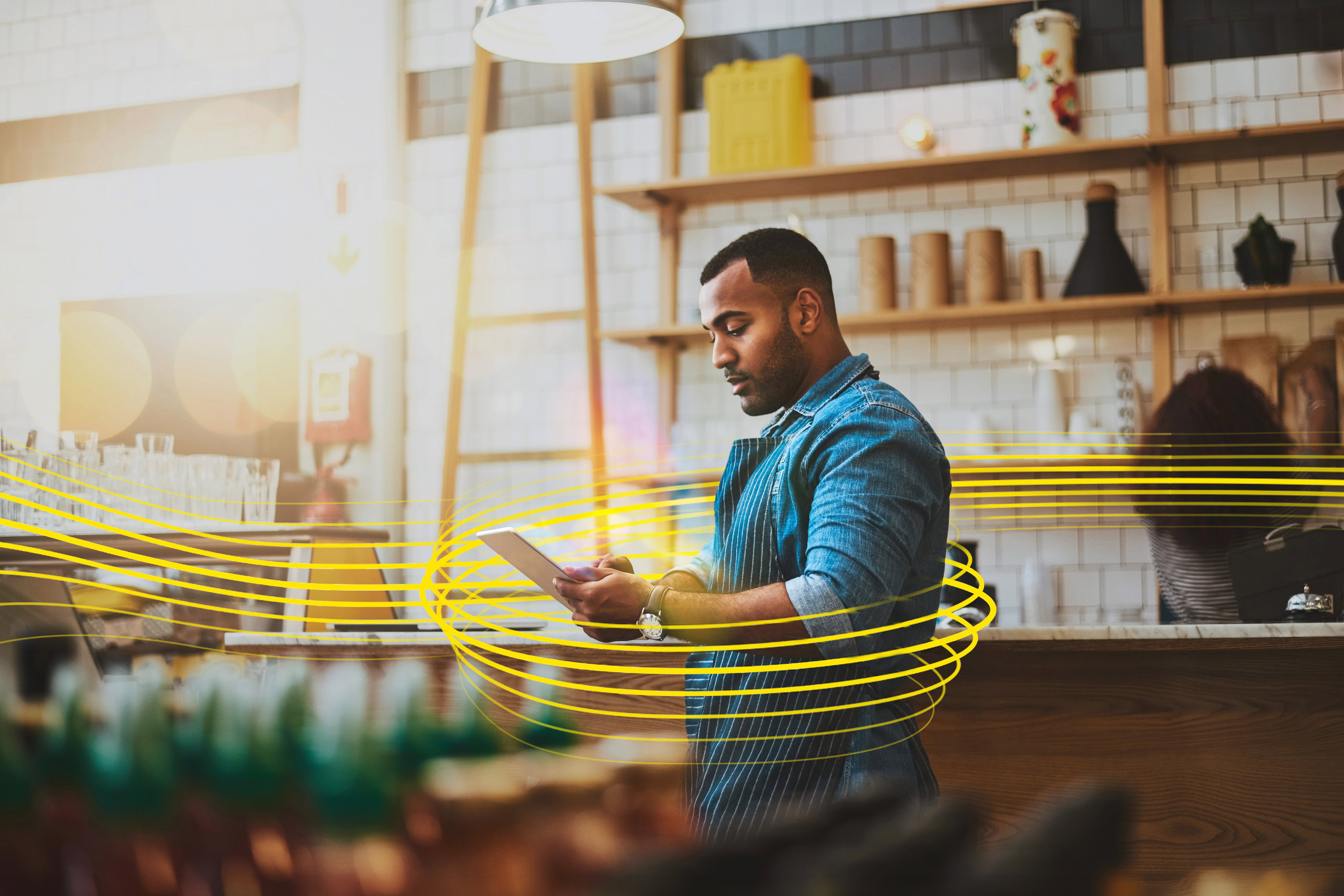Focused manager on a tablet in a café, representing online entrepreneurship in retail, tech, food and coffee businesses.