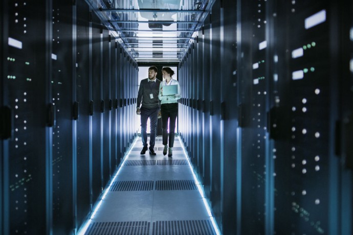 Female IT Technician and Male Server Engineer Working in a Data Center