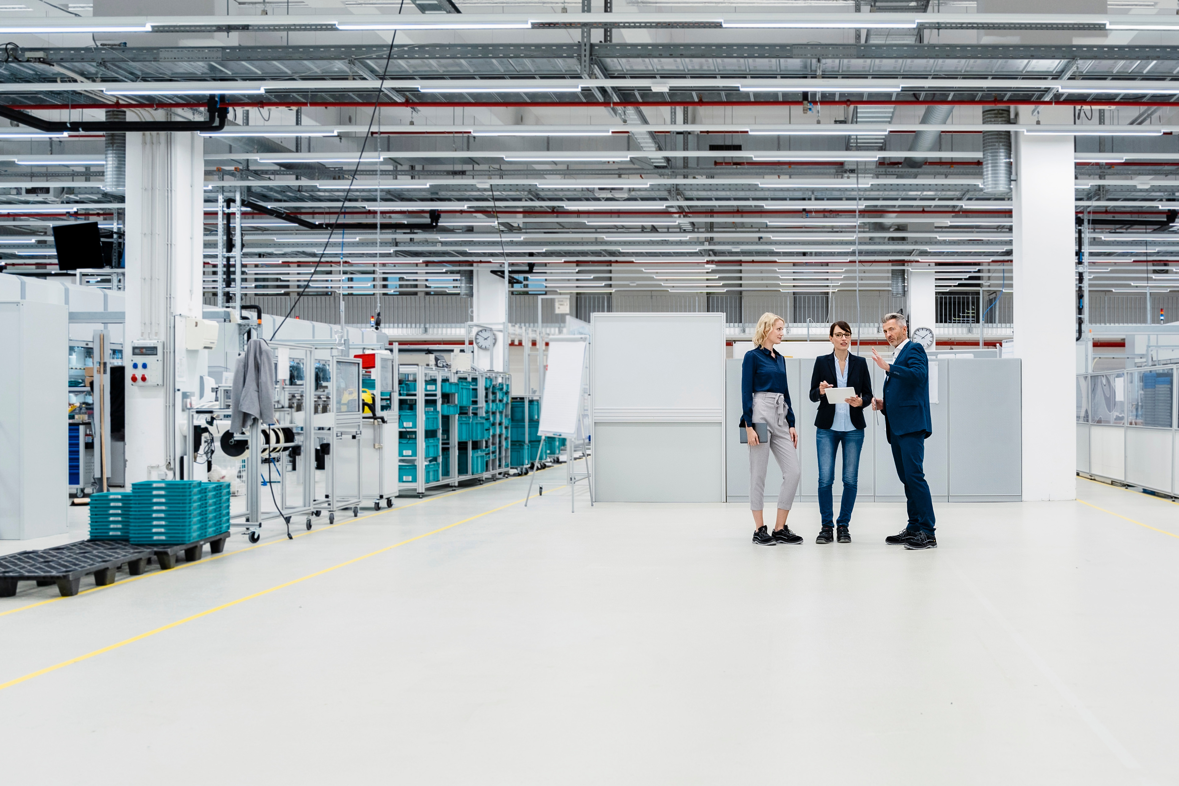 Three people talking factory floor
