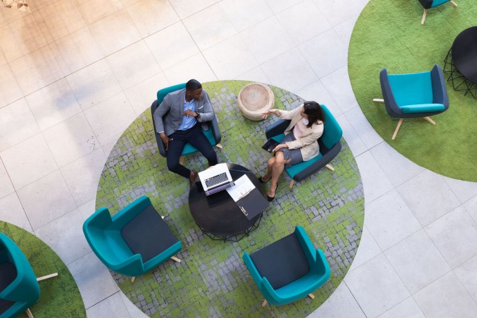 Overhead view of diverse businessman and businesswoman discussing together at modern office