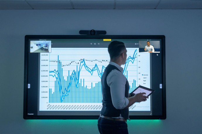Businessman using video conferencing with graph on interactive screen in business meeting