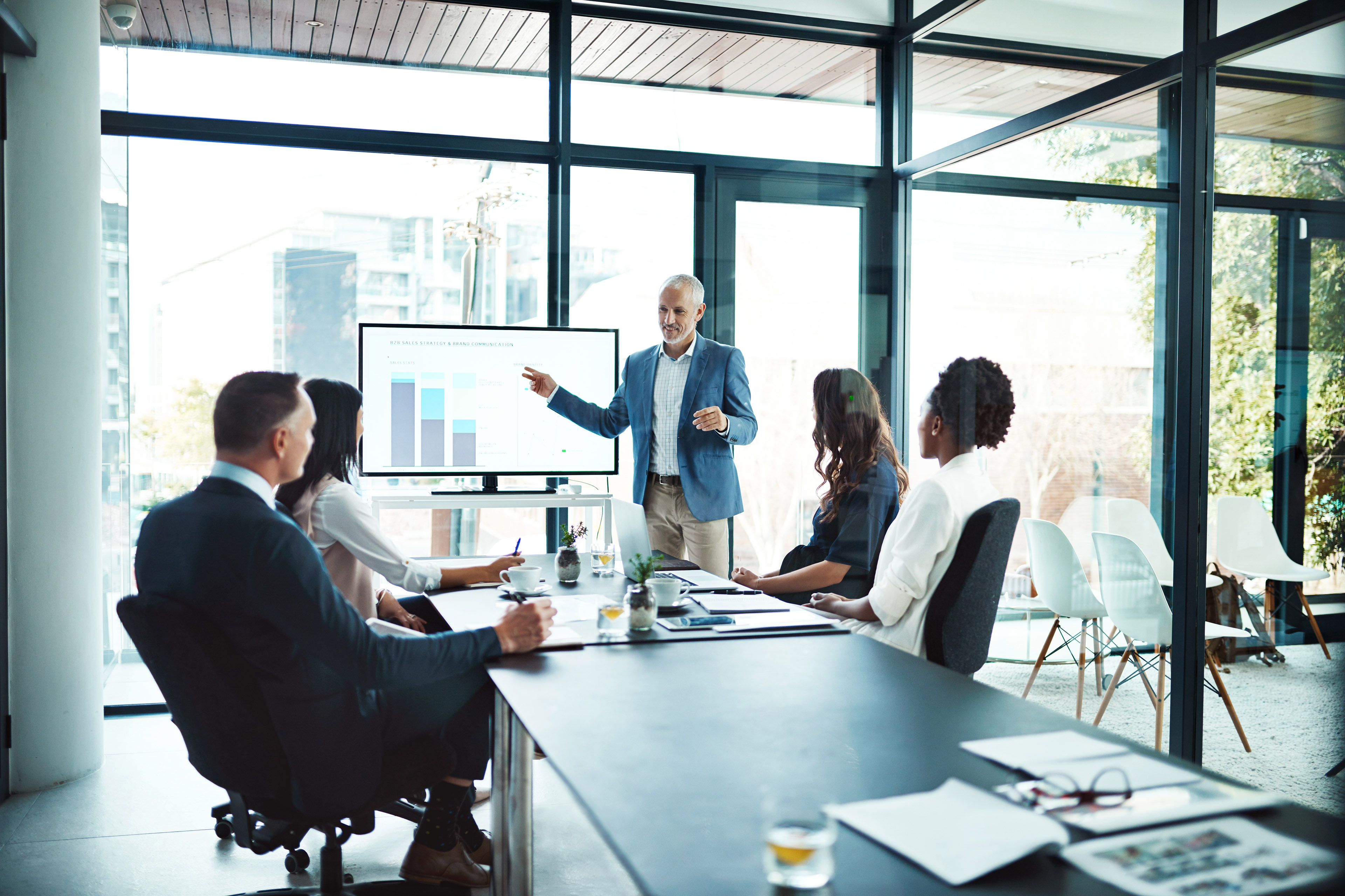 Business man showing graphs on monitor to stakeholders