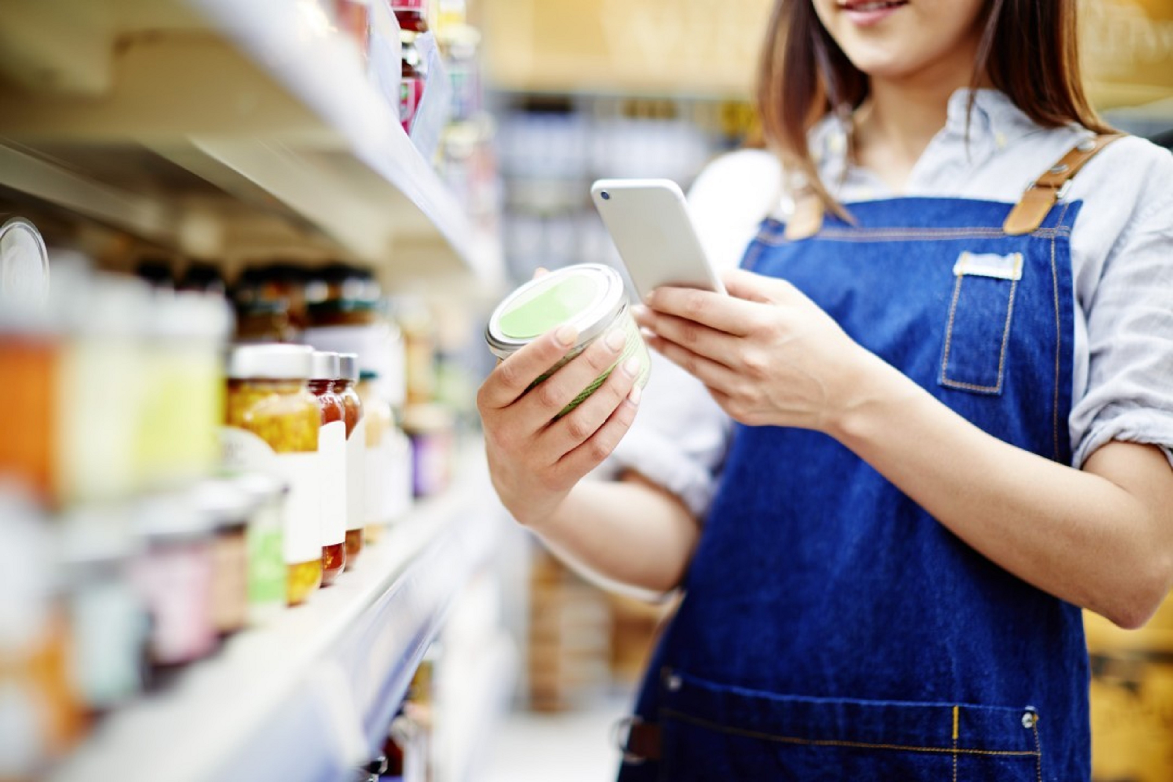 A woman in an apron with a cell phone in her hand