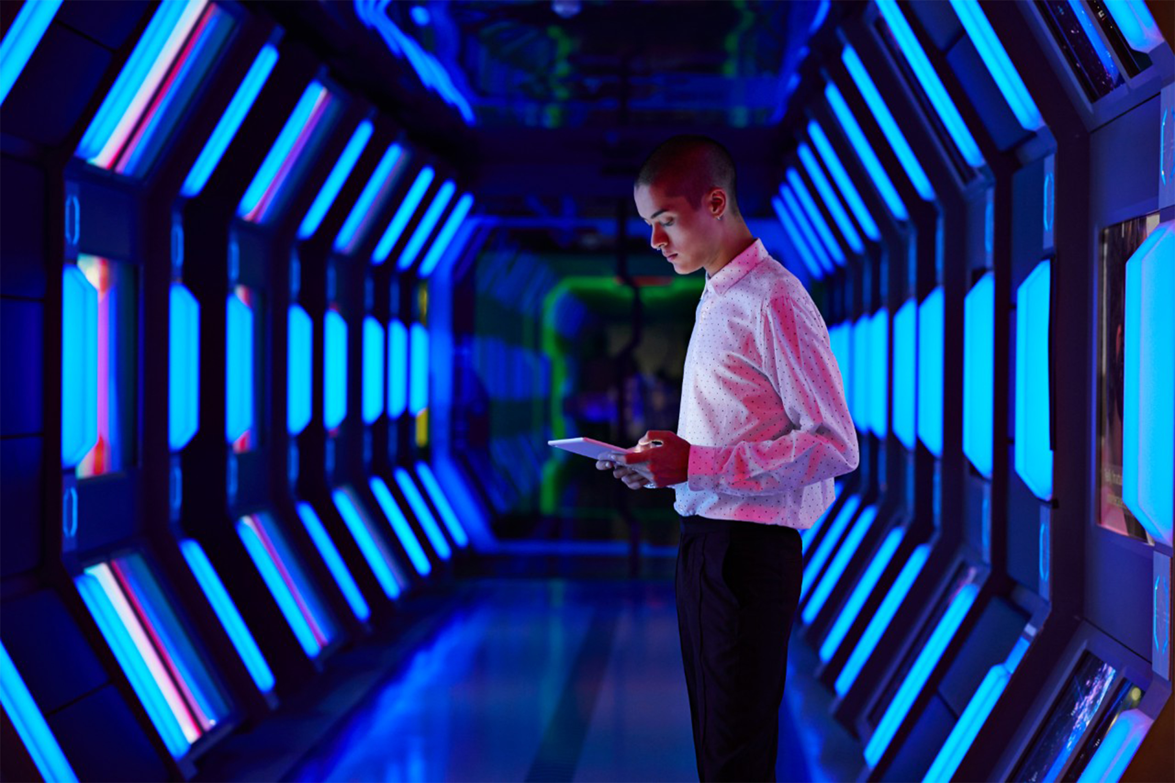 Young businessman looking at digital tablet in spaceship like corridor 