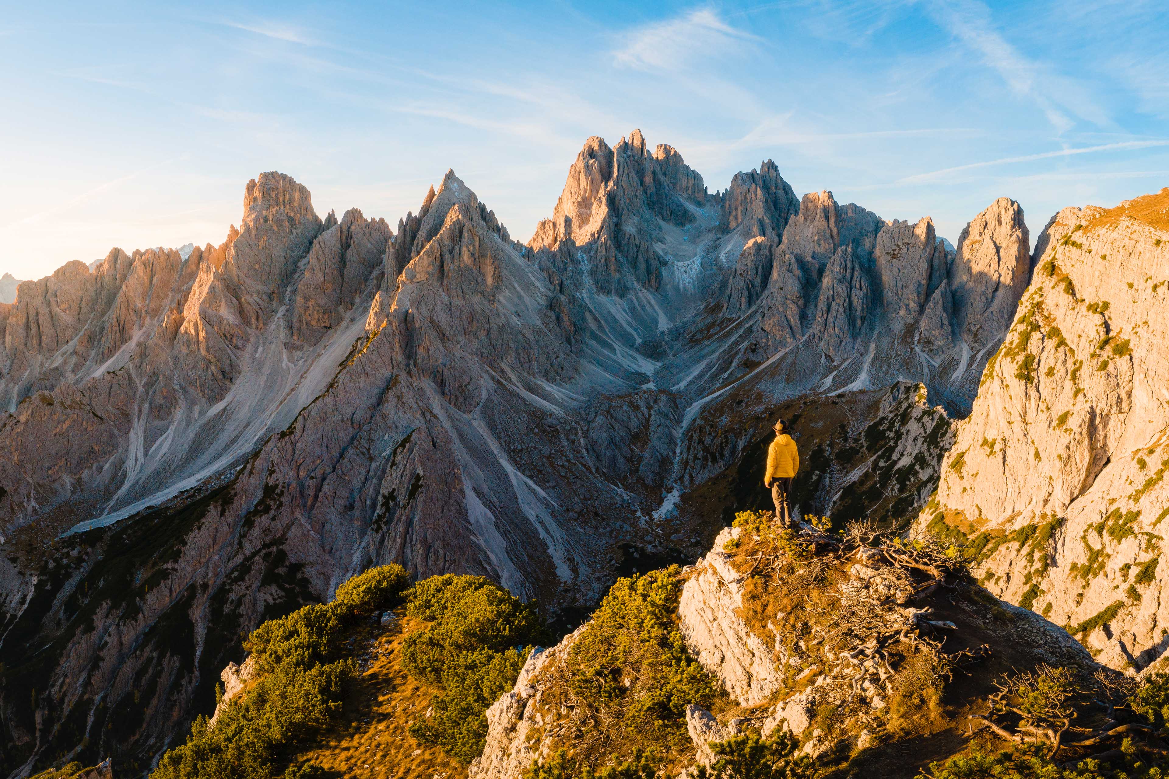 Persoon die op een bergkam staat en uitkijkt over de Dolomieten in Italië