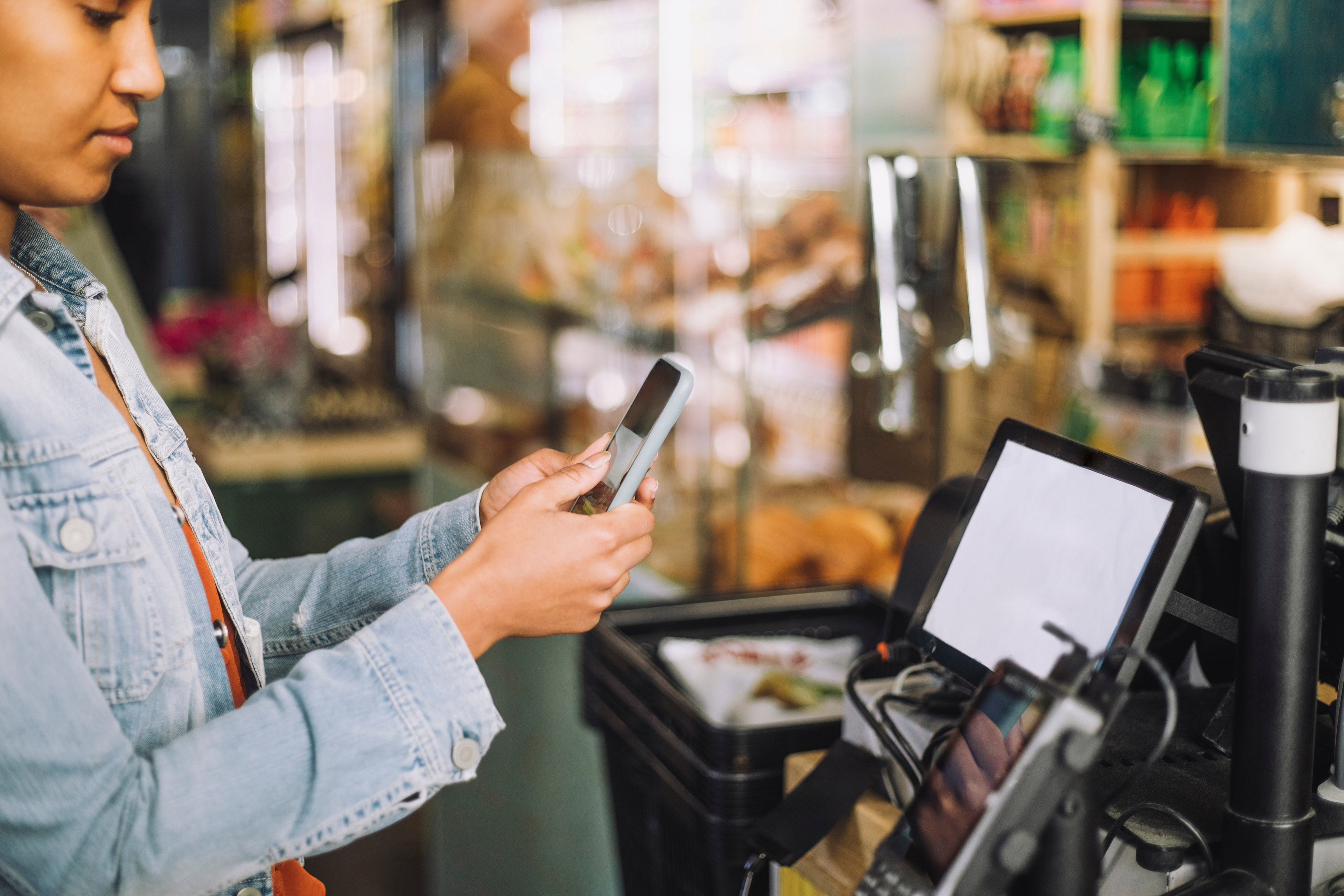 Persoon betaalt met een smartphone bij de kassa met een QR-code