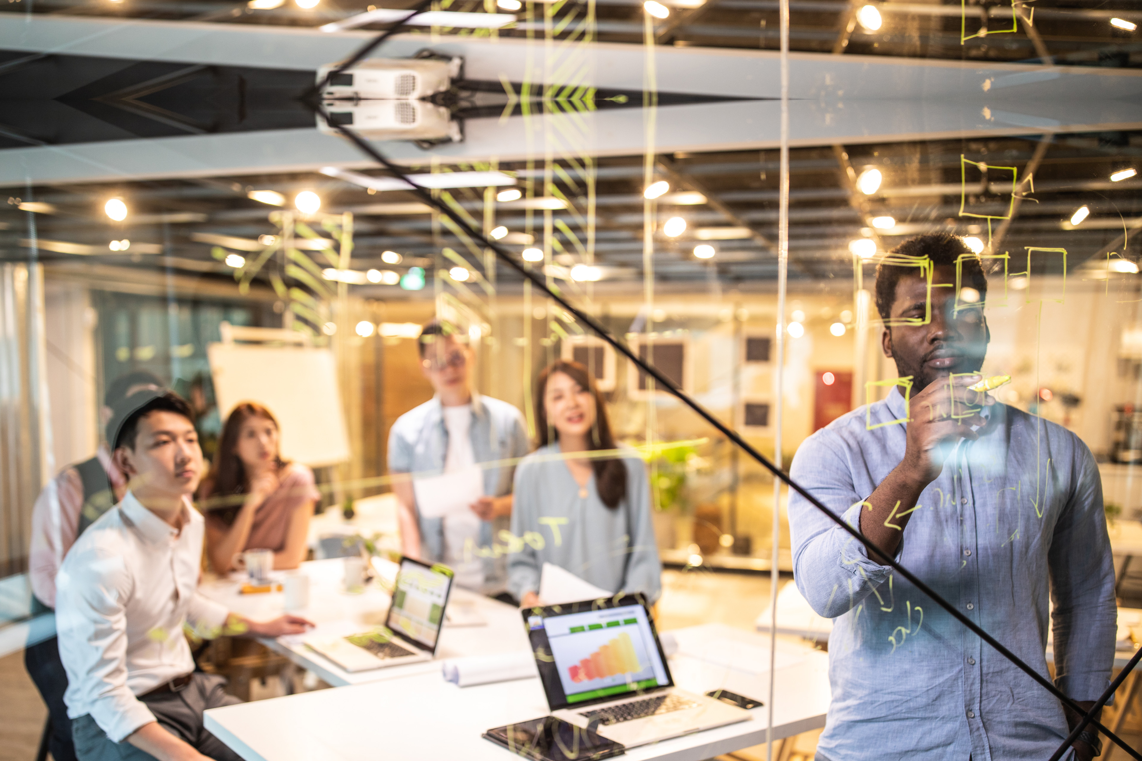 EY Startup Hub pessoas em um quadro de brainstorming