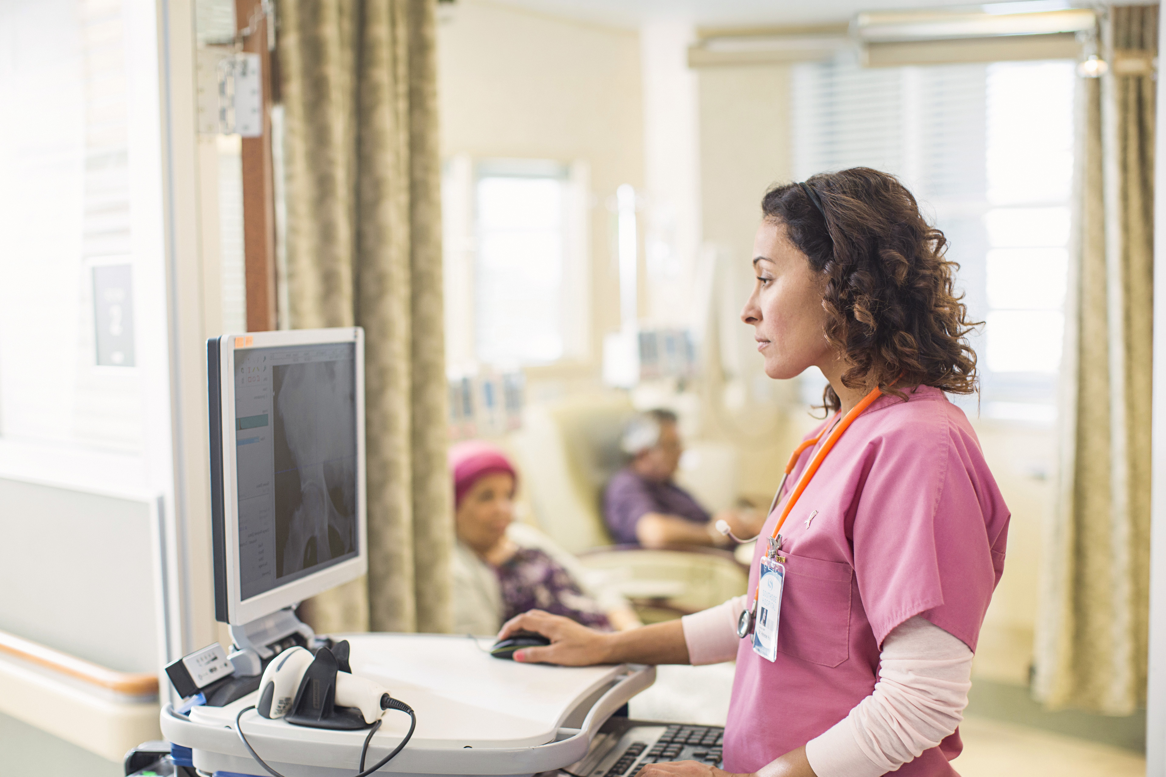 médica olhando um monitor em um quarto de hospital