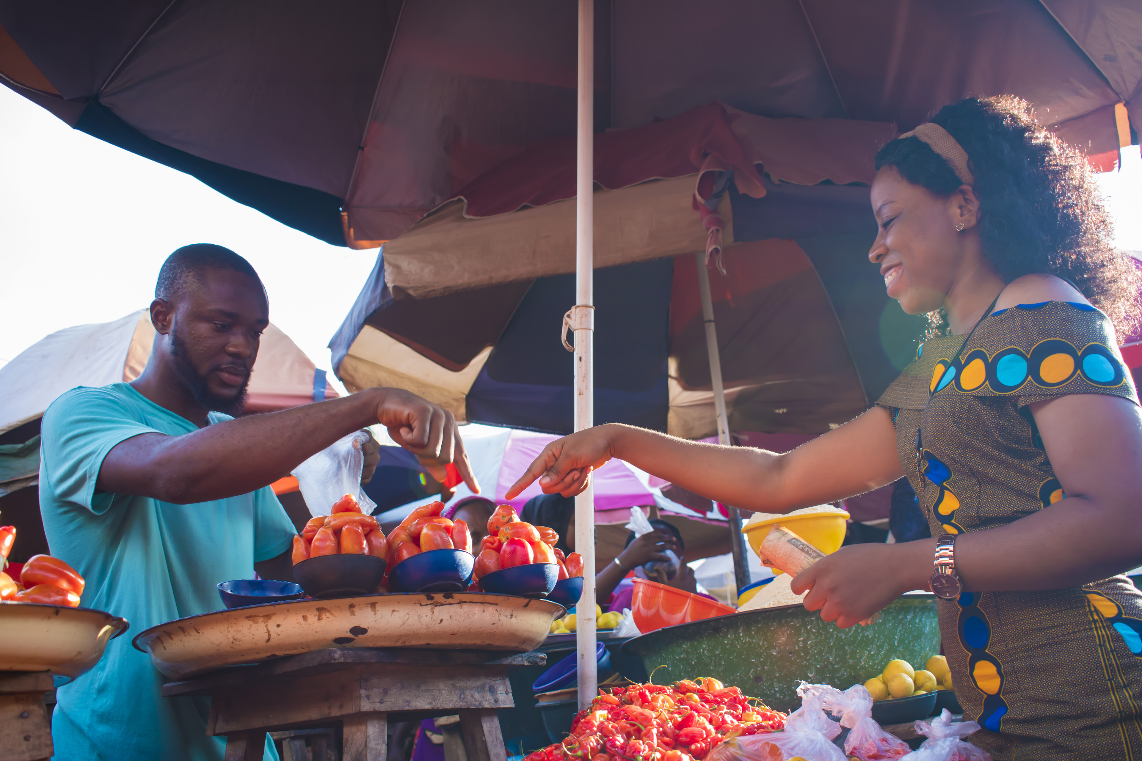 Man selling tomatoes to a young woman