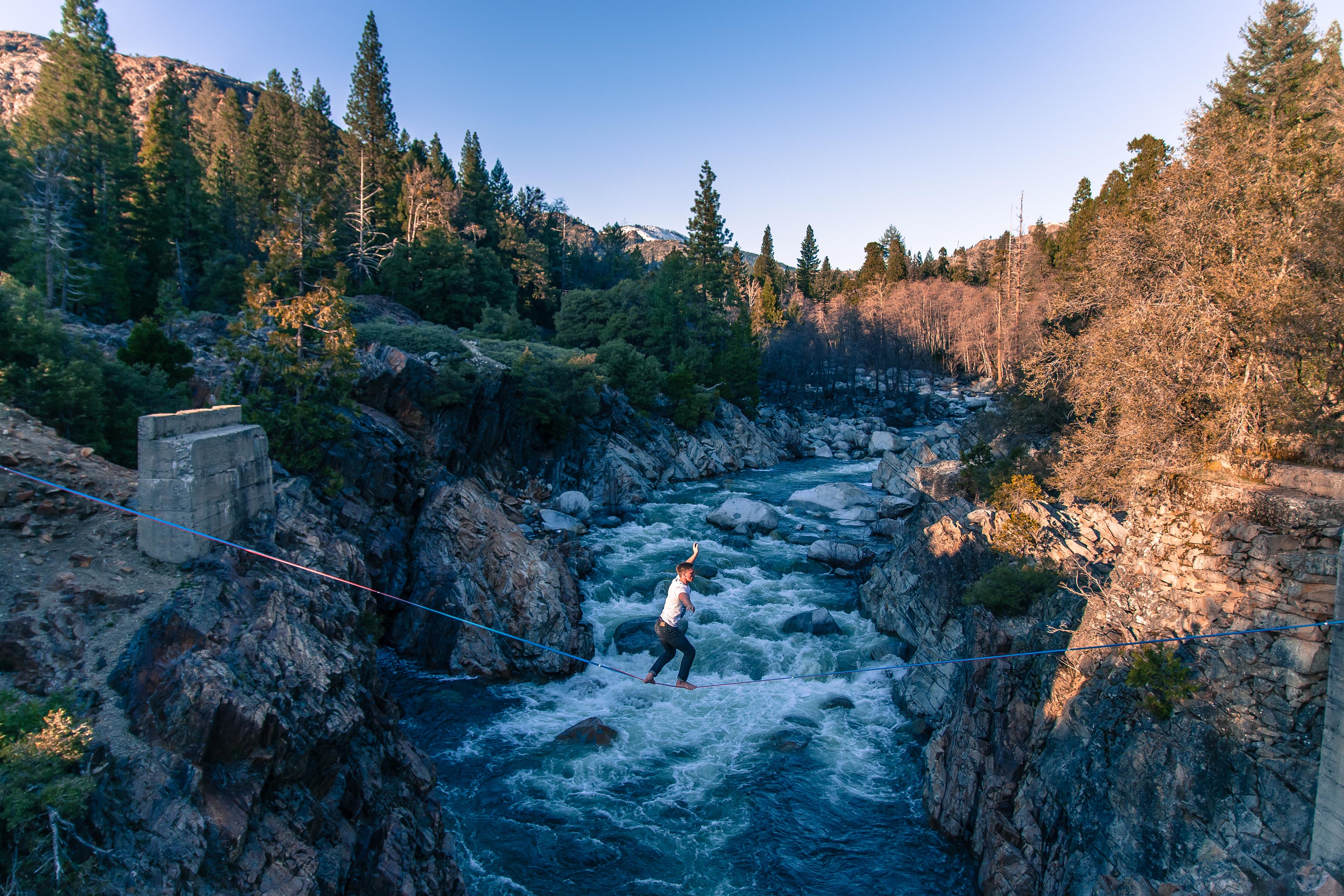 ey-man-slacklining-over-rocky-river-canyon