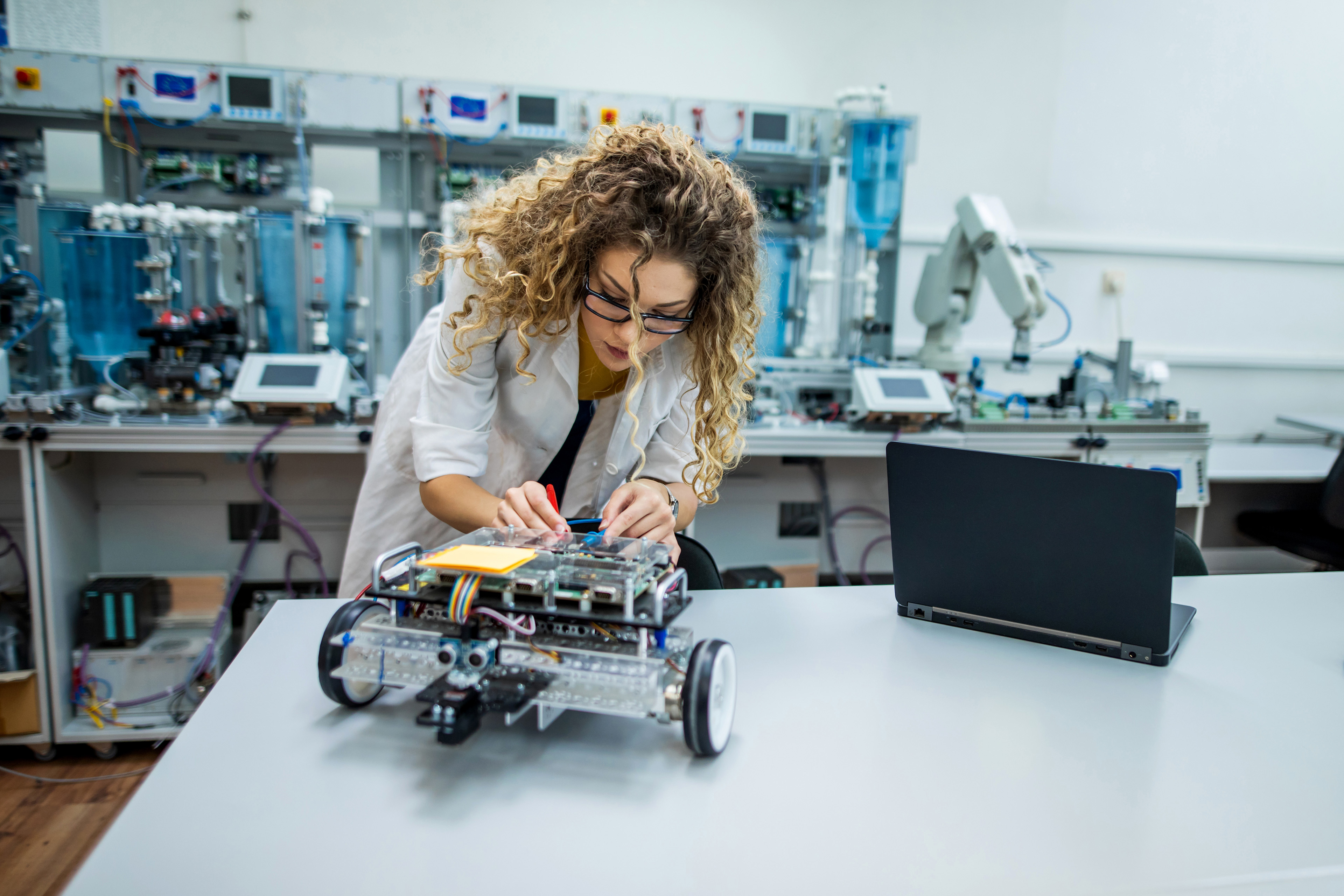 Kvinna skruvar på robot