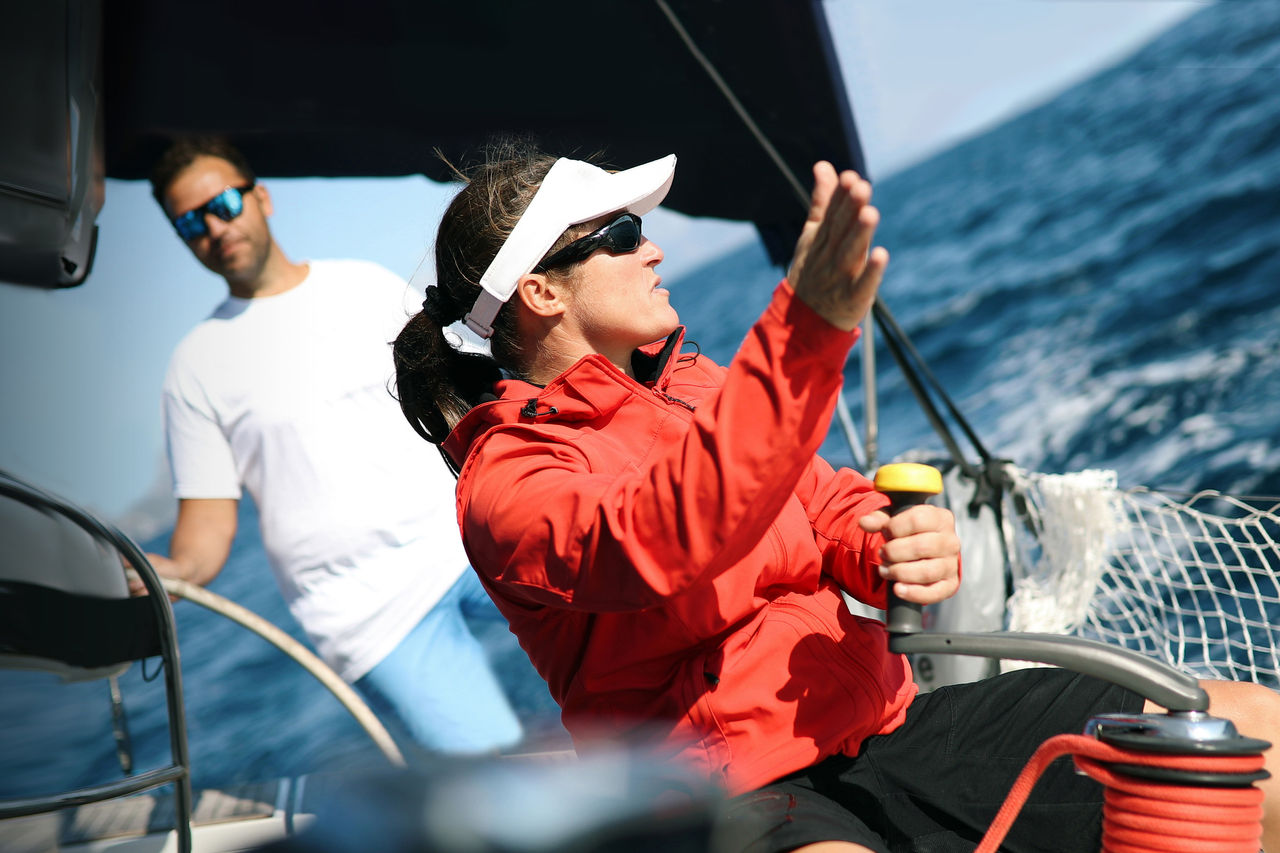 Female sailboat captain in red jacket