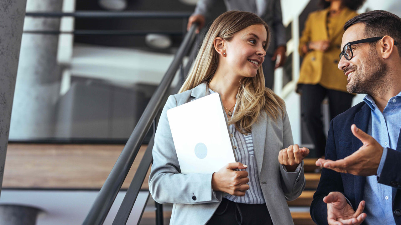 Professionelles Gespräch zwischen Kollegen auf einer modernen Bürotreppe