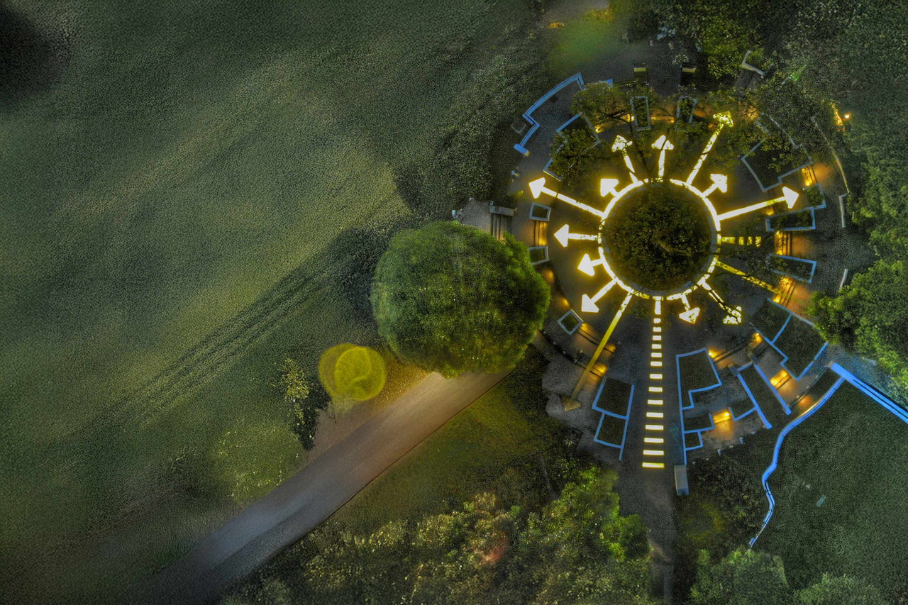 Diese beeindruckende Luftaufnahme zeigt einen kreisförmigen Platz, der von leuchtenden Pfeilen umgeben ist.