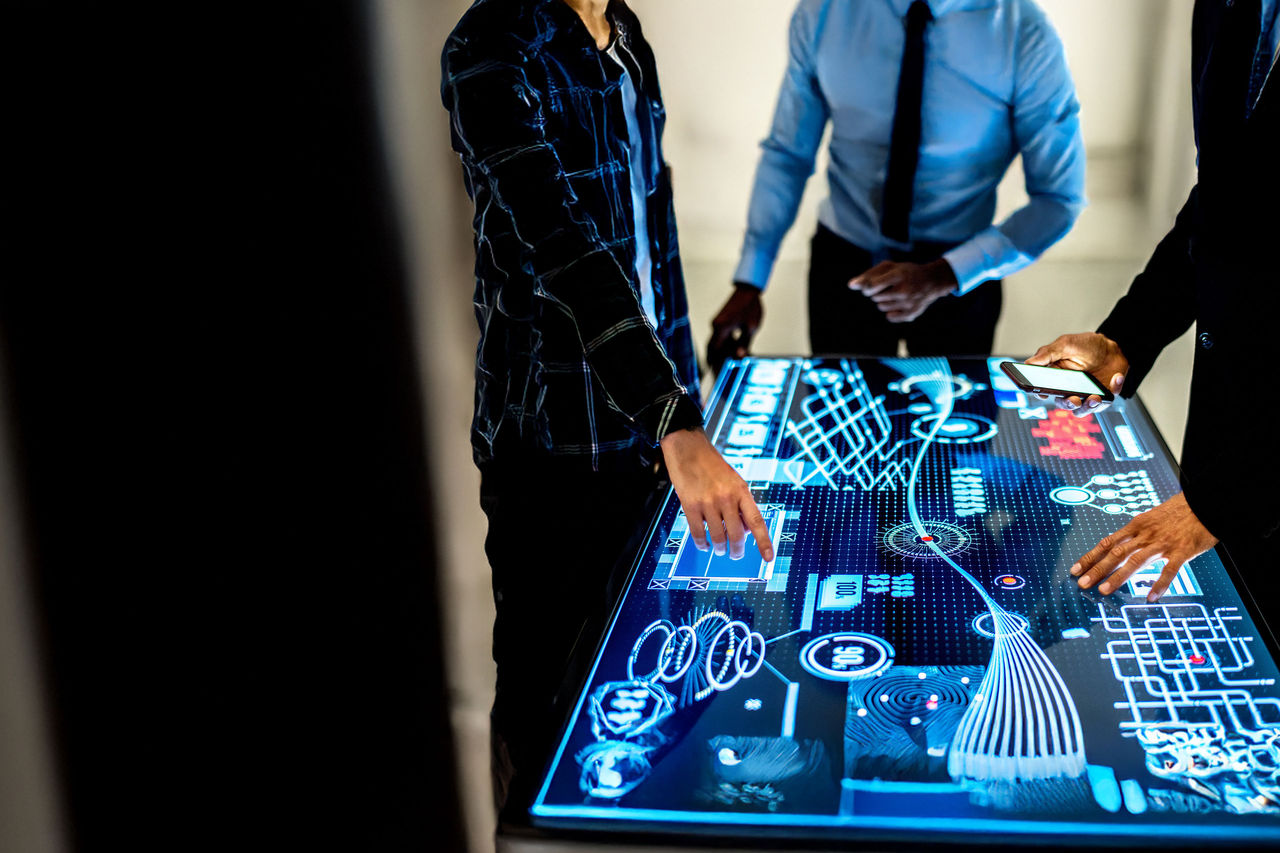 Geschäftsteam analysiert digitale Daten auf interaktivem Touchscreen für Strategie und Innovation