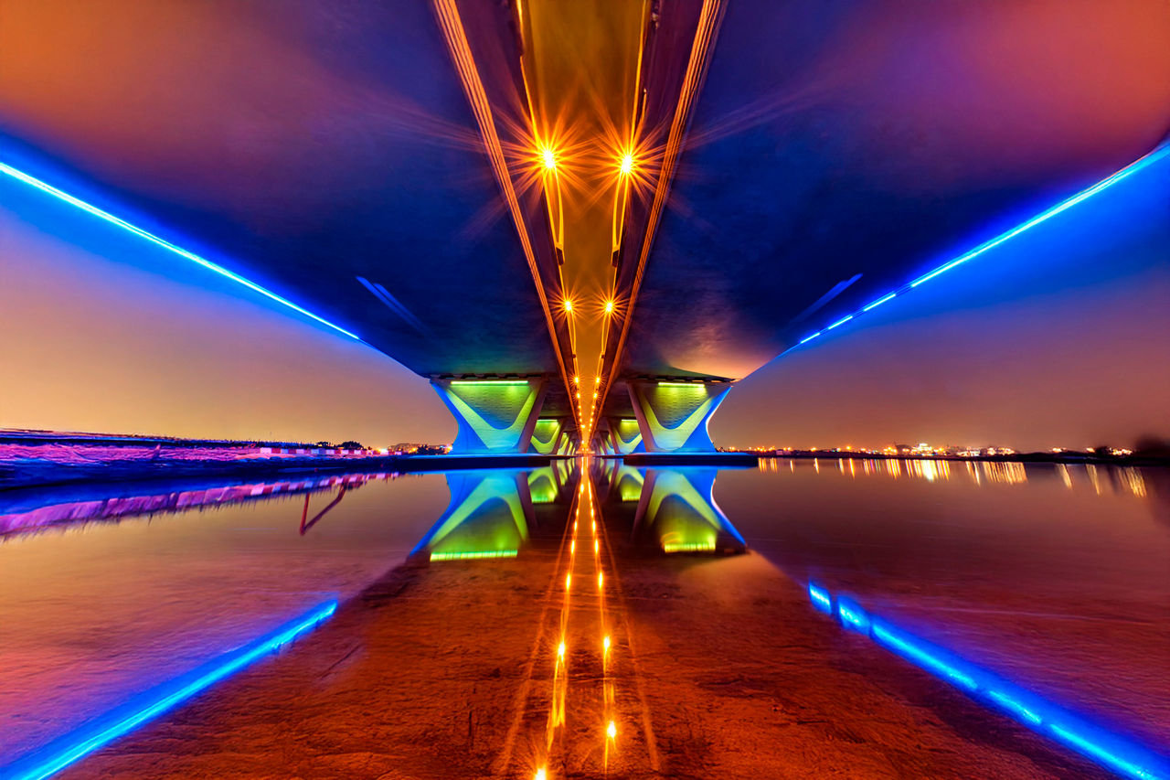 Illuminated underside of bridge at night