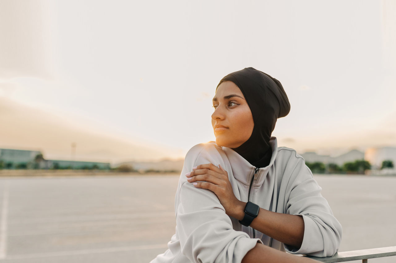 Sportswoman with a hijab taking a breather during her morning workout session