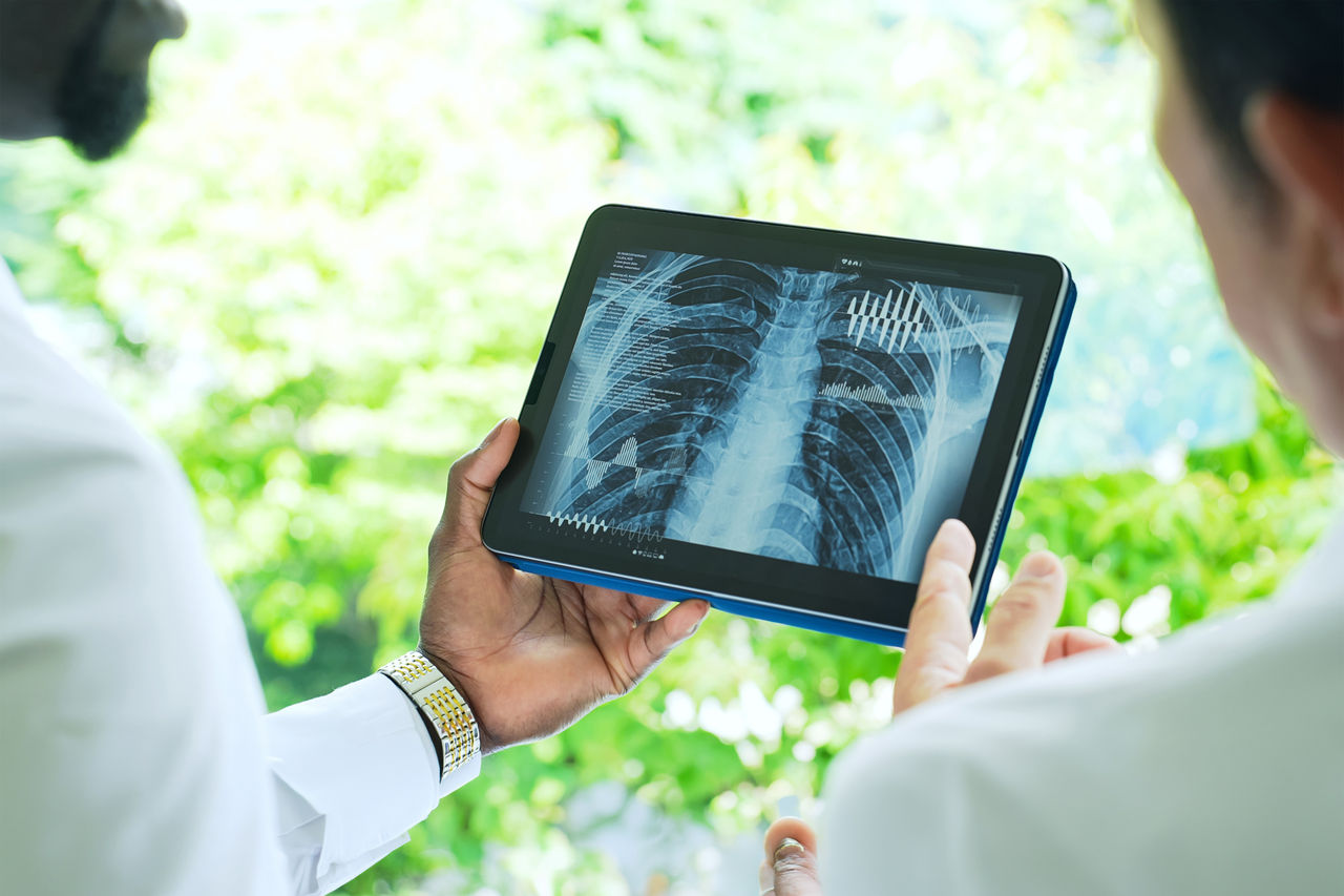 A group of researchers looking at medical data on a tablet